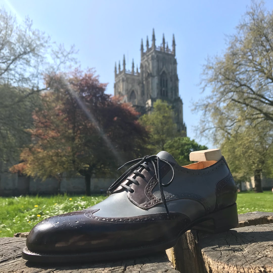 bespoke black and blue shoe in front of the York minster
